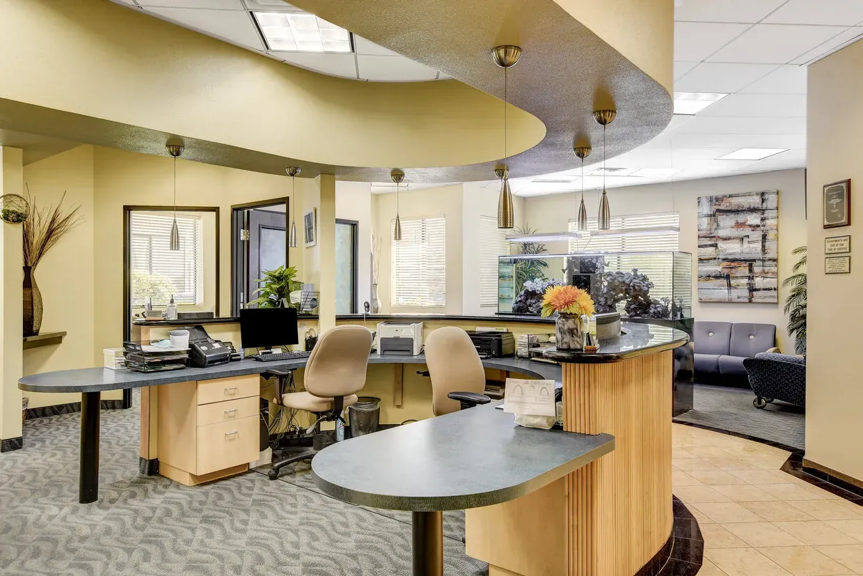 Front office and reception counter under a curved ceiling with pendant lights